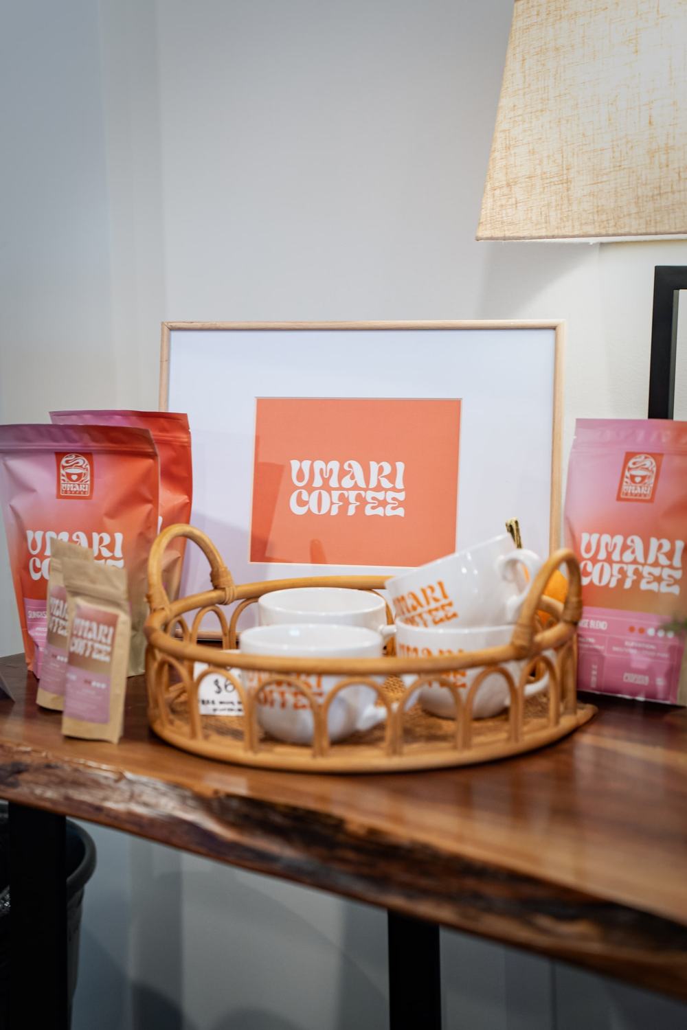 Coffee bags, cups and a framed logo arranged on a wooden table display