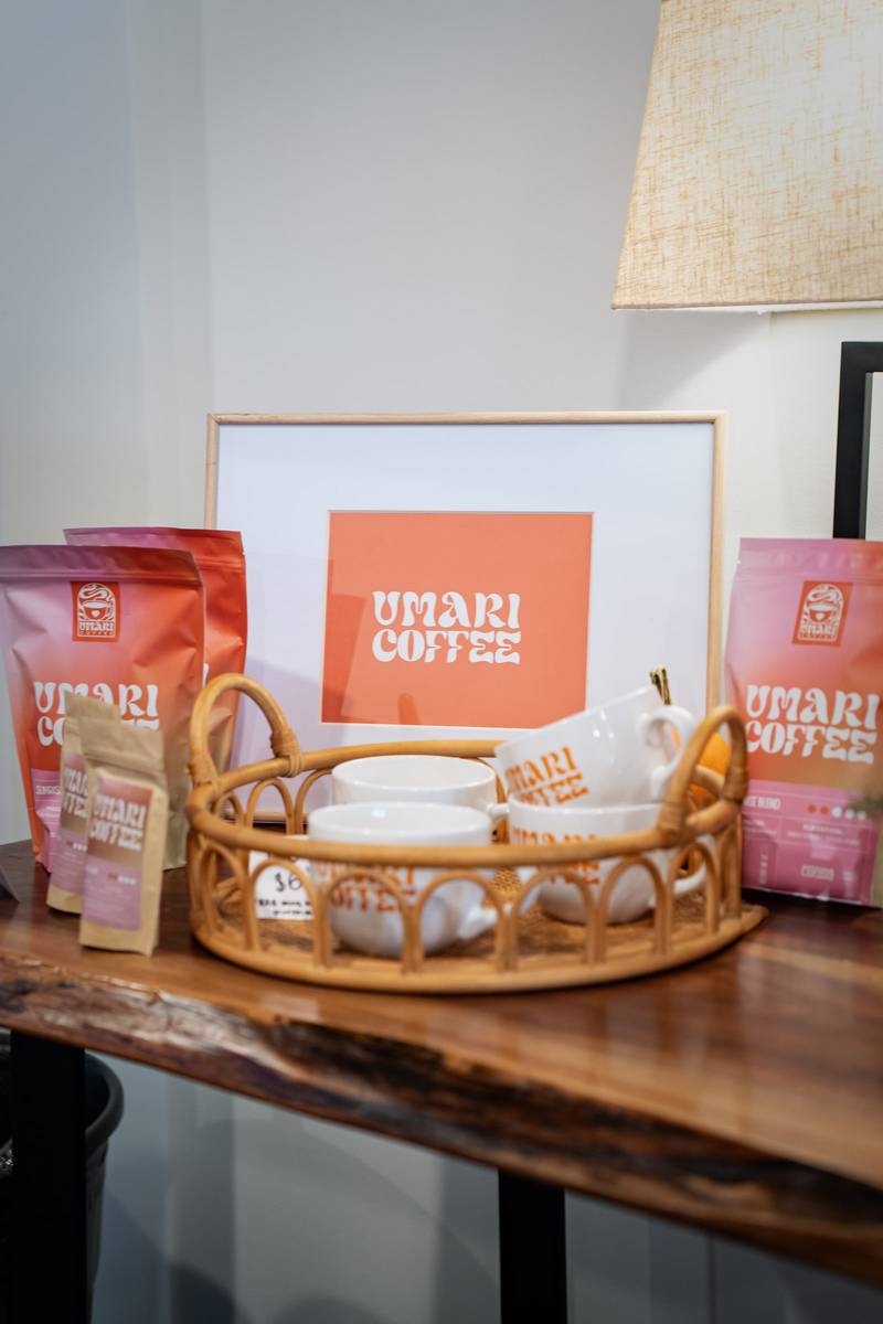 Coffee bags, cups and a framed logo arranged on a wooden table display